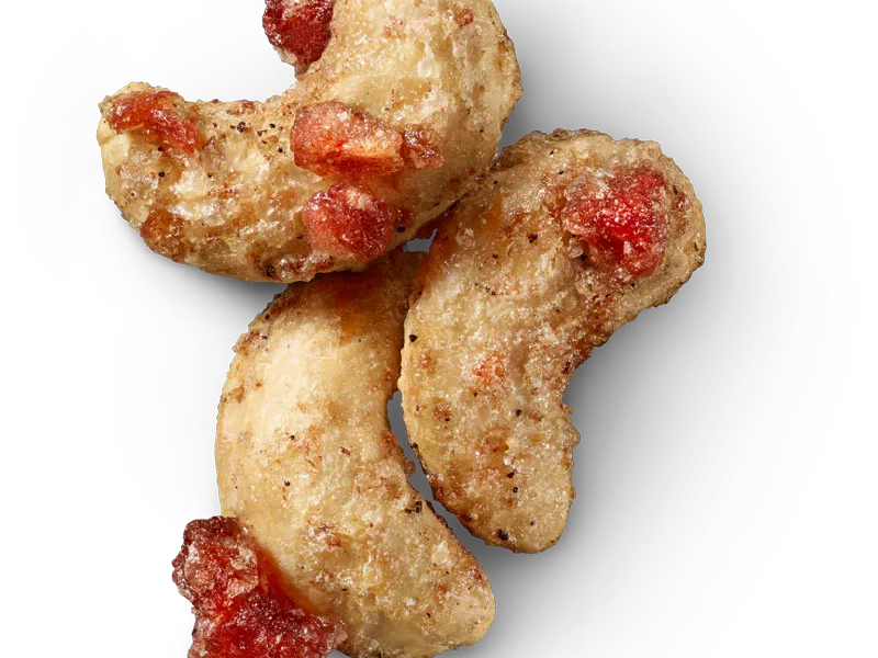 Glazed cashews with red pomegranate pieces and vanilla-speckled coating.